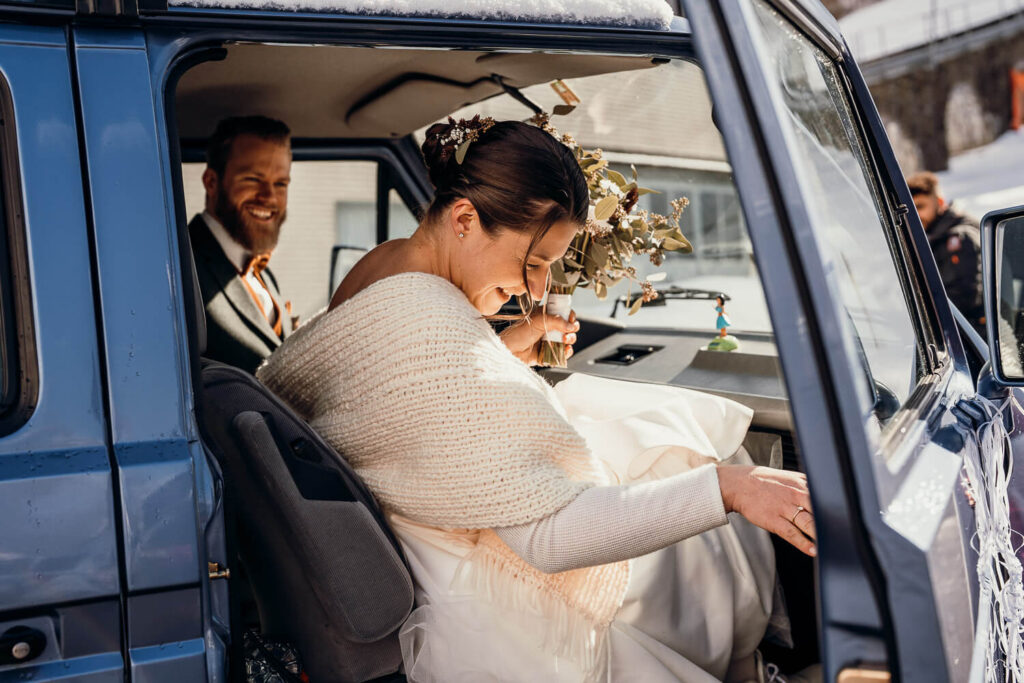 Braut steigt in Auto ein